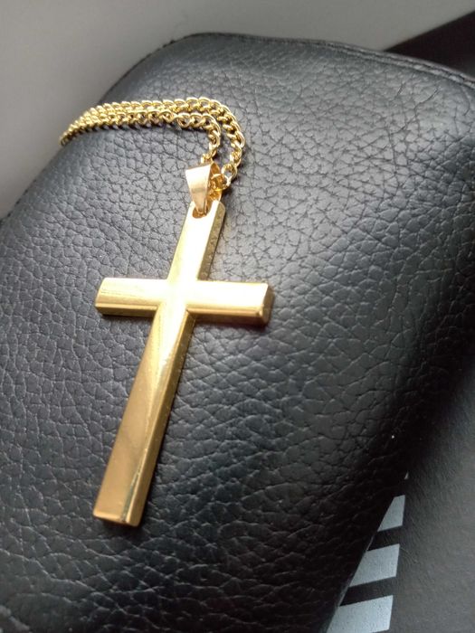 Łańcuszek z krzyżykiem w kolorze złotym.