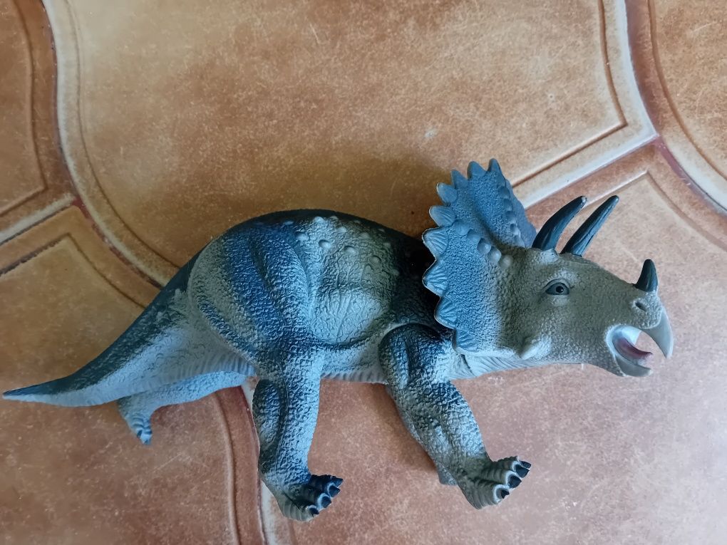 Brinquedos plásticos do dinossauro com pés móveis