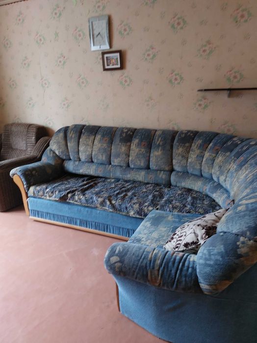 Кутовий диван, синього кольору, зручний для відпочинку.