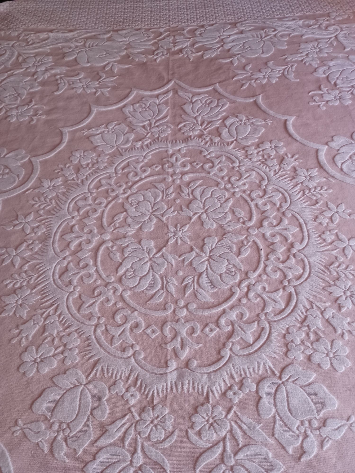 Colcha de de casal cor de rosa com desenhos florais.