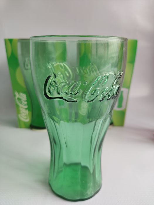 Coca-Cola copos de vidro e latas.
