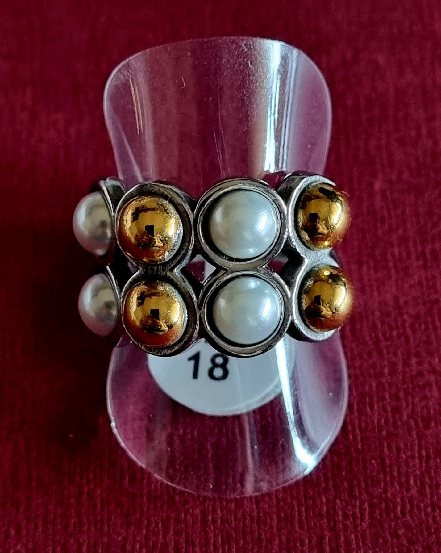 Anel prateado, em aço, com pérolas e bolinhas douradas. T18