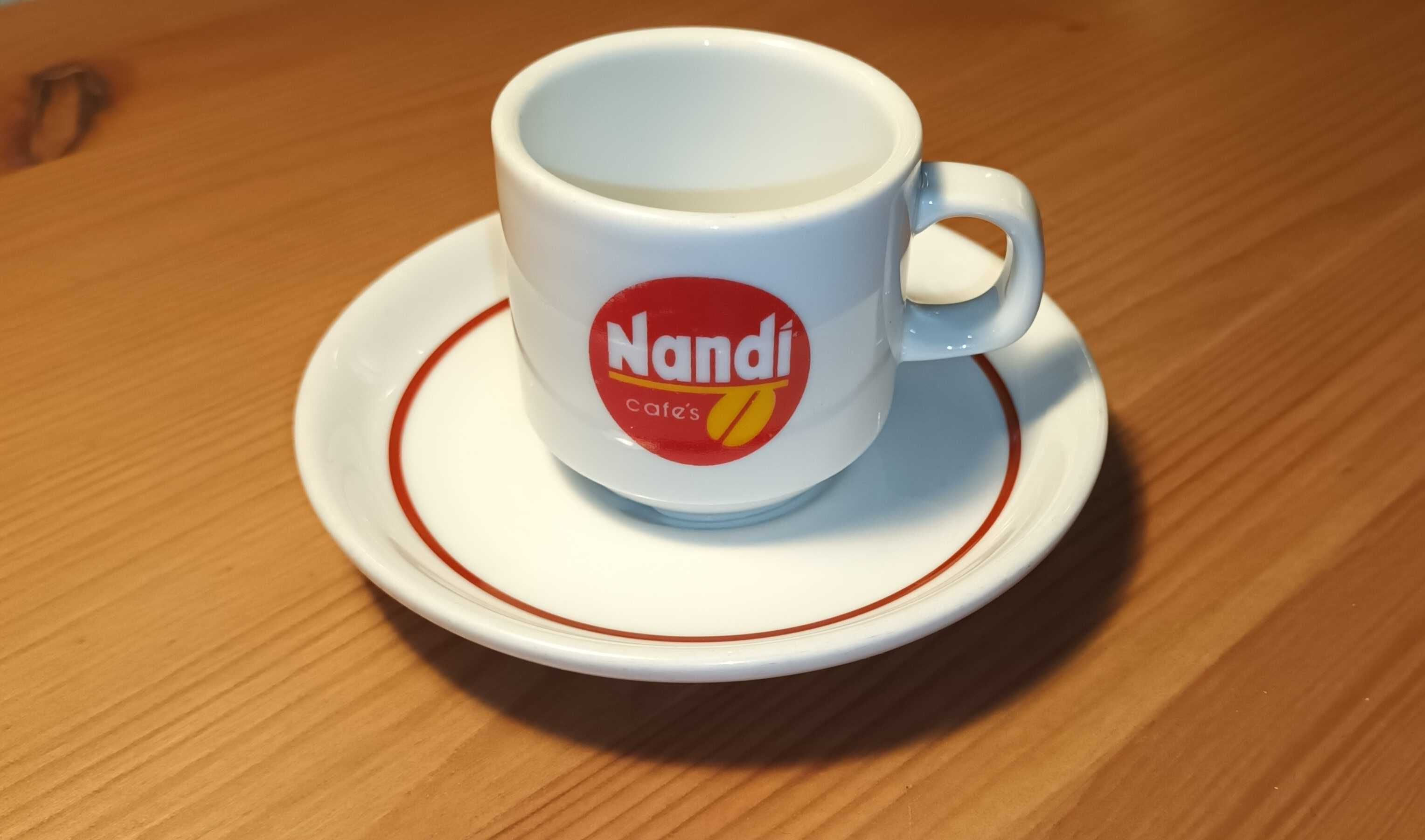 Chávena de café antiga do café "Nandi" com pires