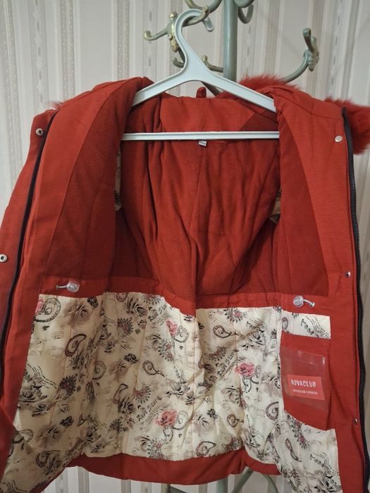 Куртка-парка червоного кольору з капюшоном, оздобленим хутром.