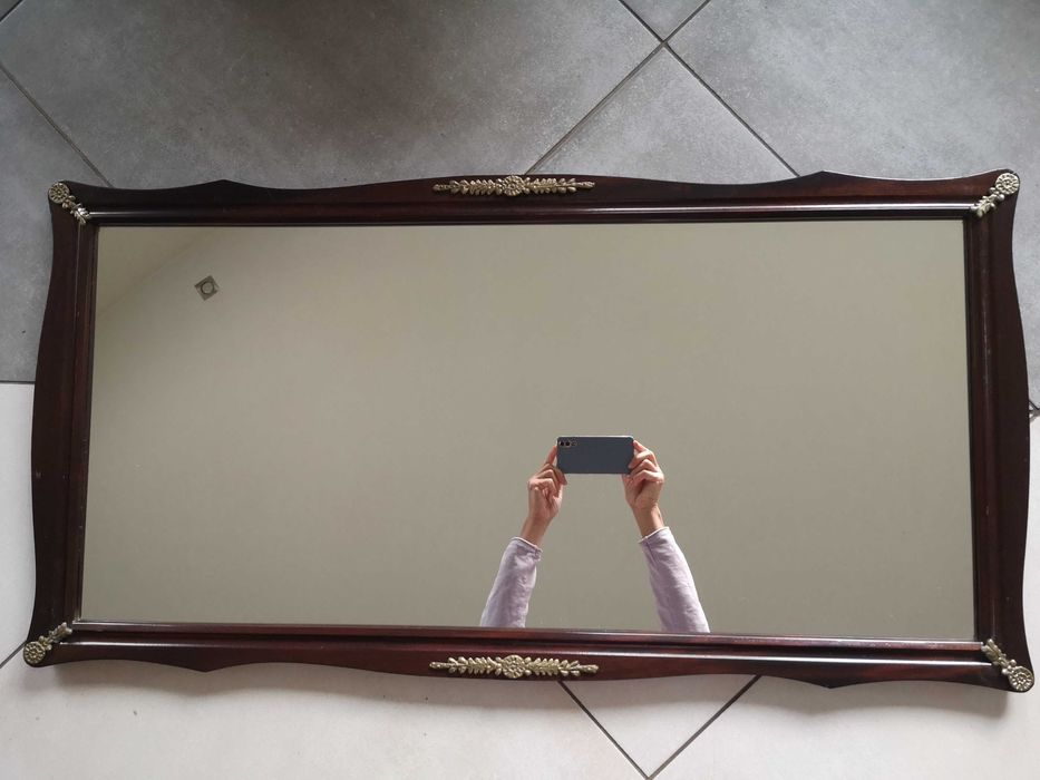 Stare lustro w drewnianej ramie z mosiężnymi zdobieniami