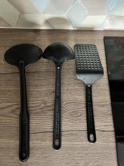 Czarne plastkikowe alcesoria kuchenne: chochla, cedzak, szpatuła