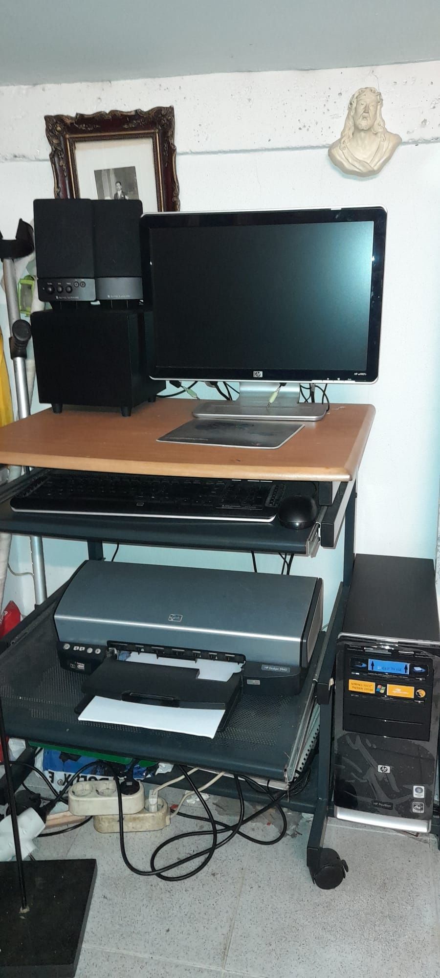 Computador HP, impressora, sistema de som e secretária.