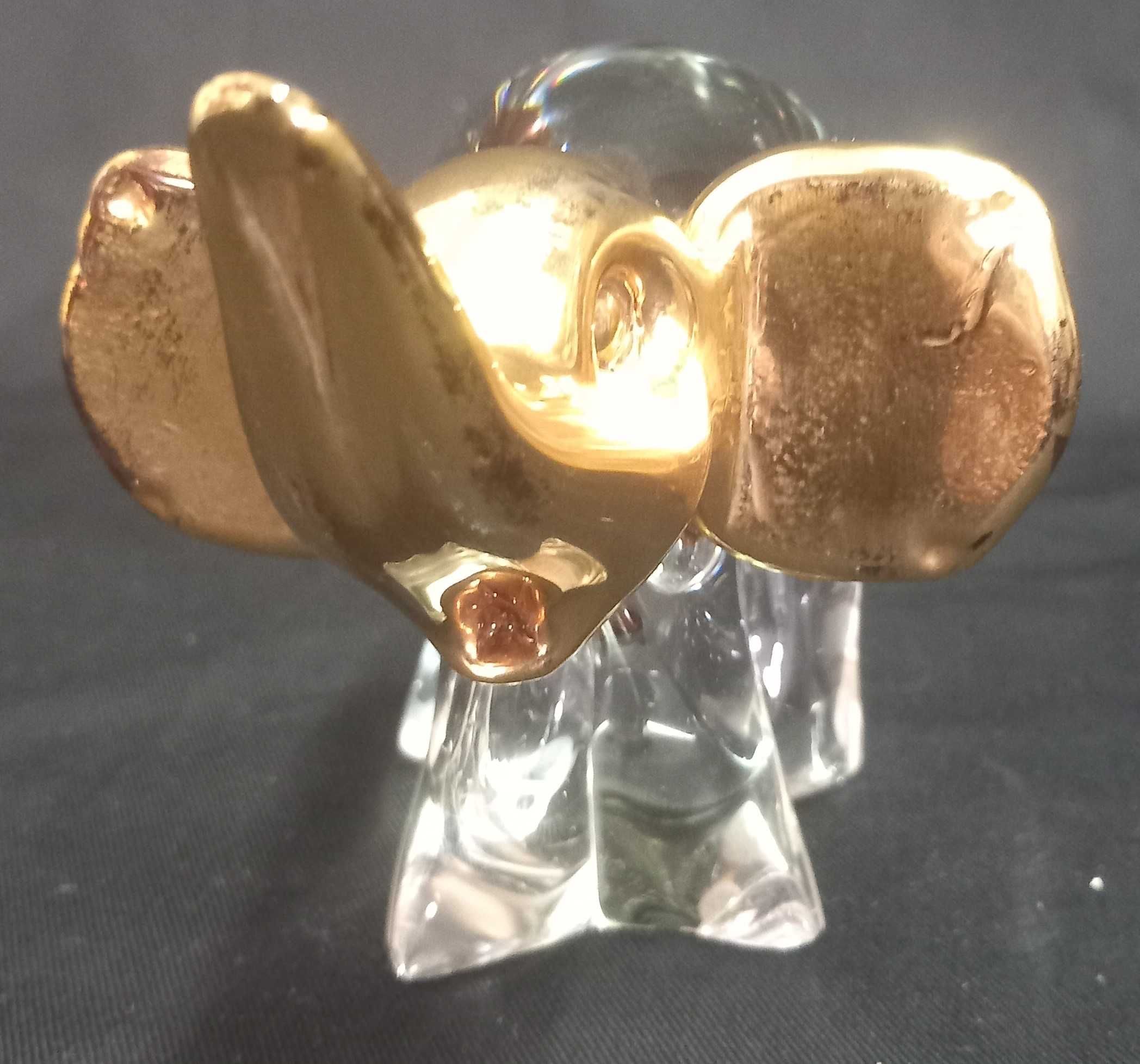 Estatueta de elefante em vidro transparente com detalhes em dourado.