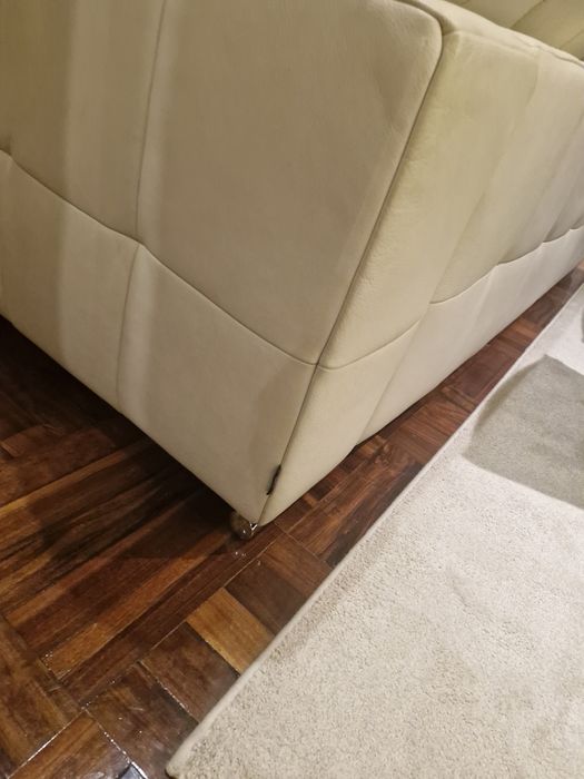 Sofá três lugares em pele beje.