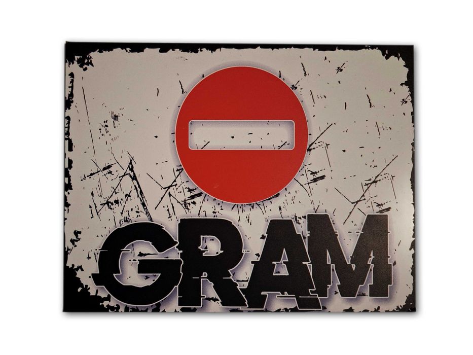 Tabliczka na drzwi z napisem GRAM i znakiem zakazu.