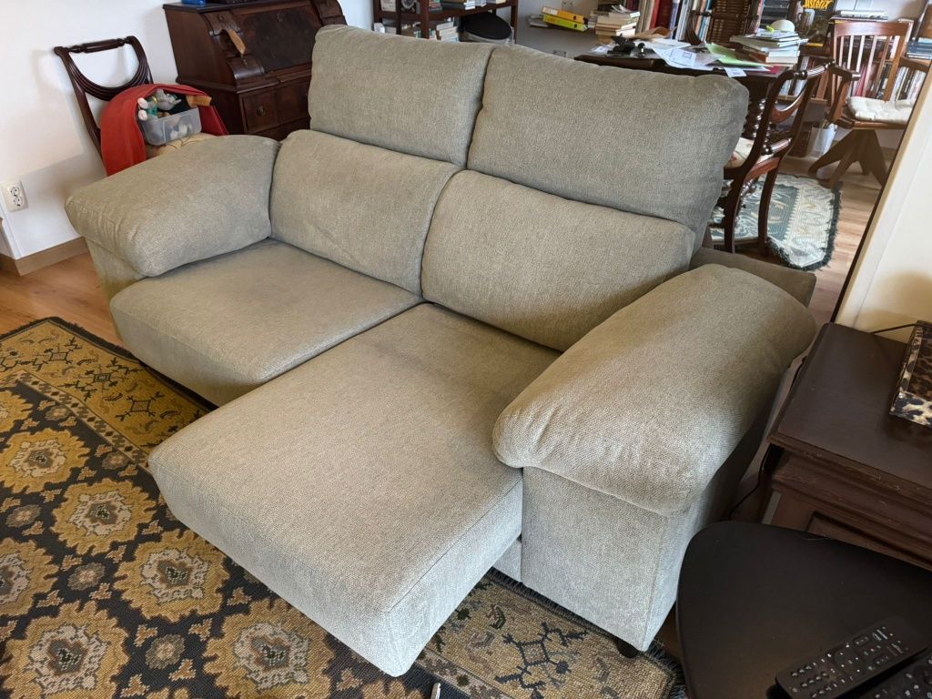 Sofá de 2 lugares com chaise long e arrumação nos braços.