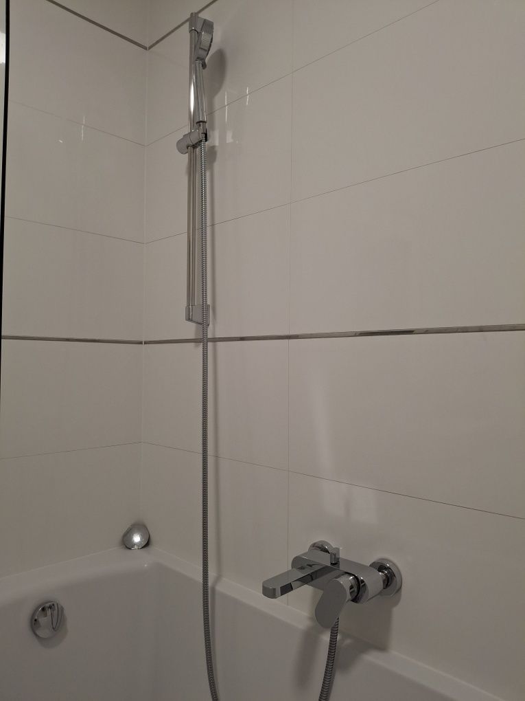 Szafka łazienkowa w zestawie z umywalką i kranem.