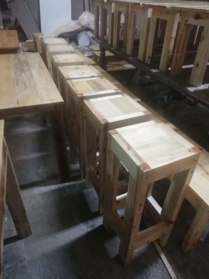 Vários tipos de mesas e bancos de madeira rústica e muito robusta.