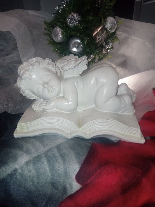 Biała Figurka Śpiącego Anioła na książce