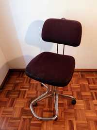 Cadeira regulável de estirador ou cavalete em tecido preto.