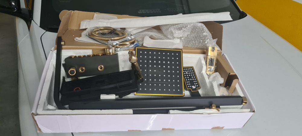 Conjunto de chuveiro, com acabamento em preto e dourado.