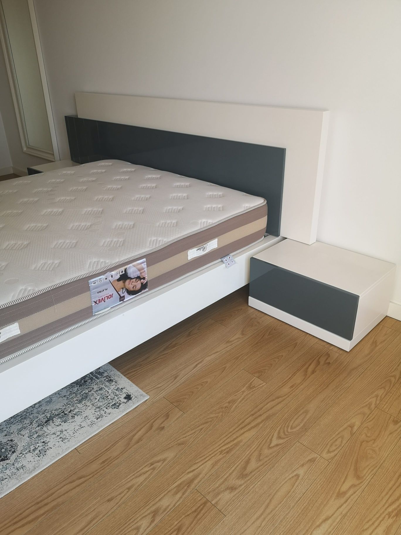 mobília de quarto em madeira branca e cinza com cama, duas mesas de c
