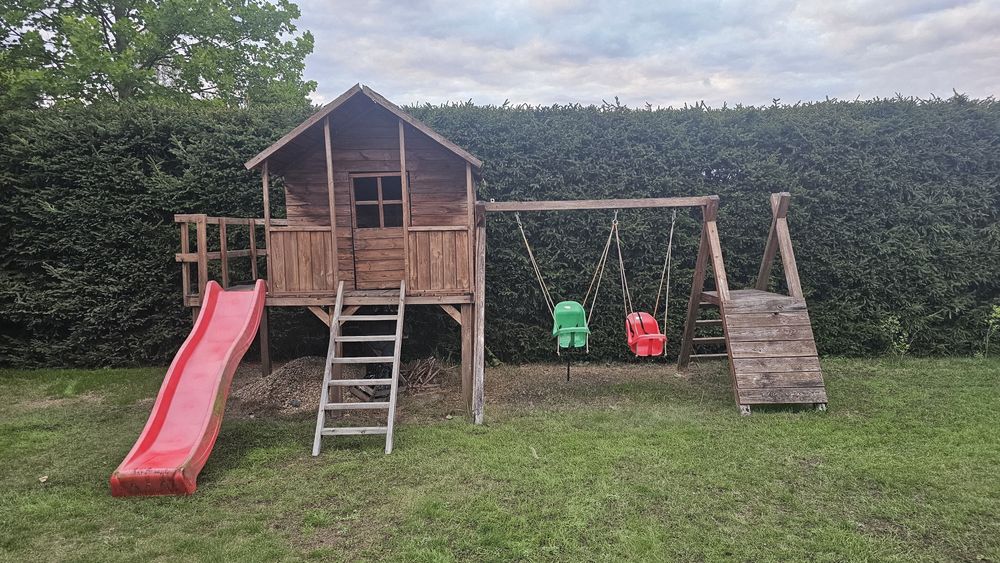 Domek dla dzieci z tarasem zjeżdżalnią huśtawkami  ścianką wspinaczkow