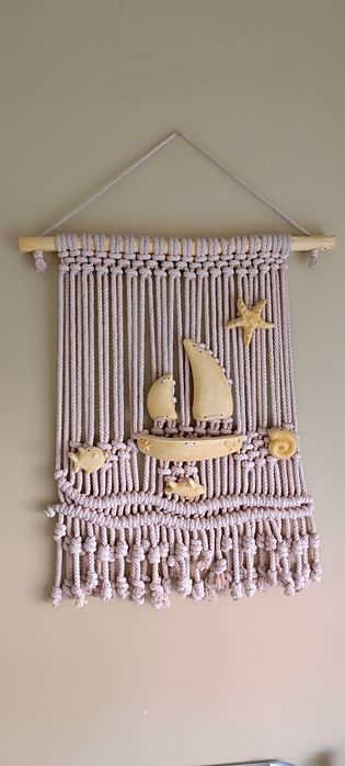 Peça decorativa macramé com barcos em amarelo . Usado