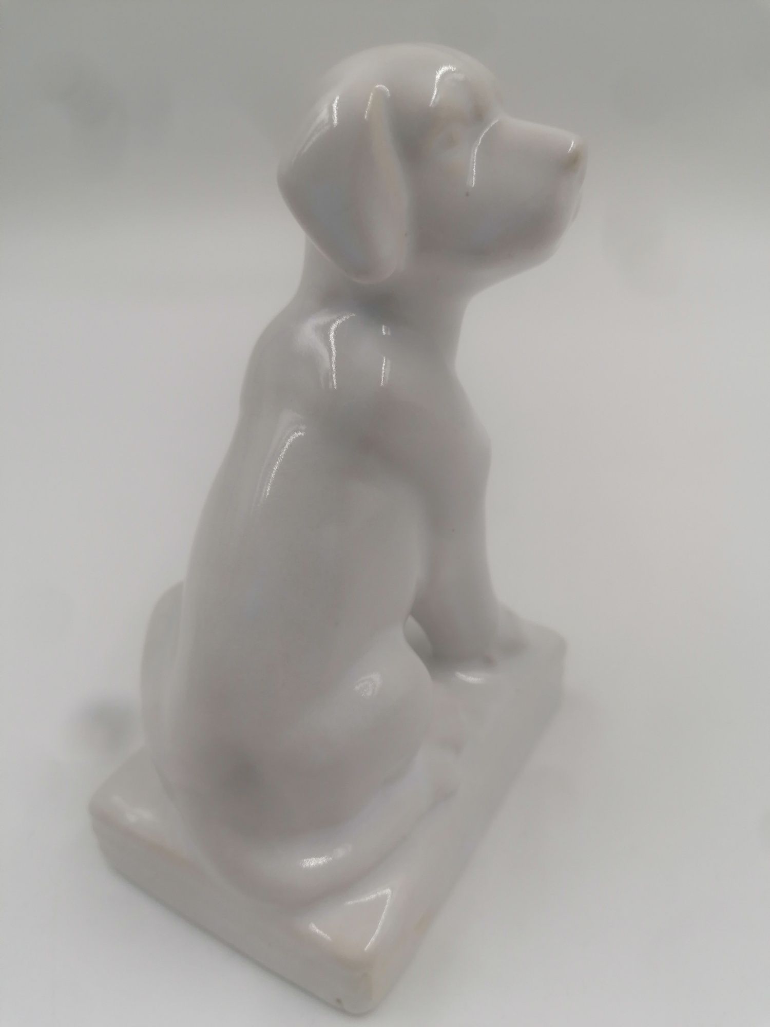 Ciekawa biała porcelanowa figurka psa na podstawie