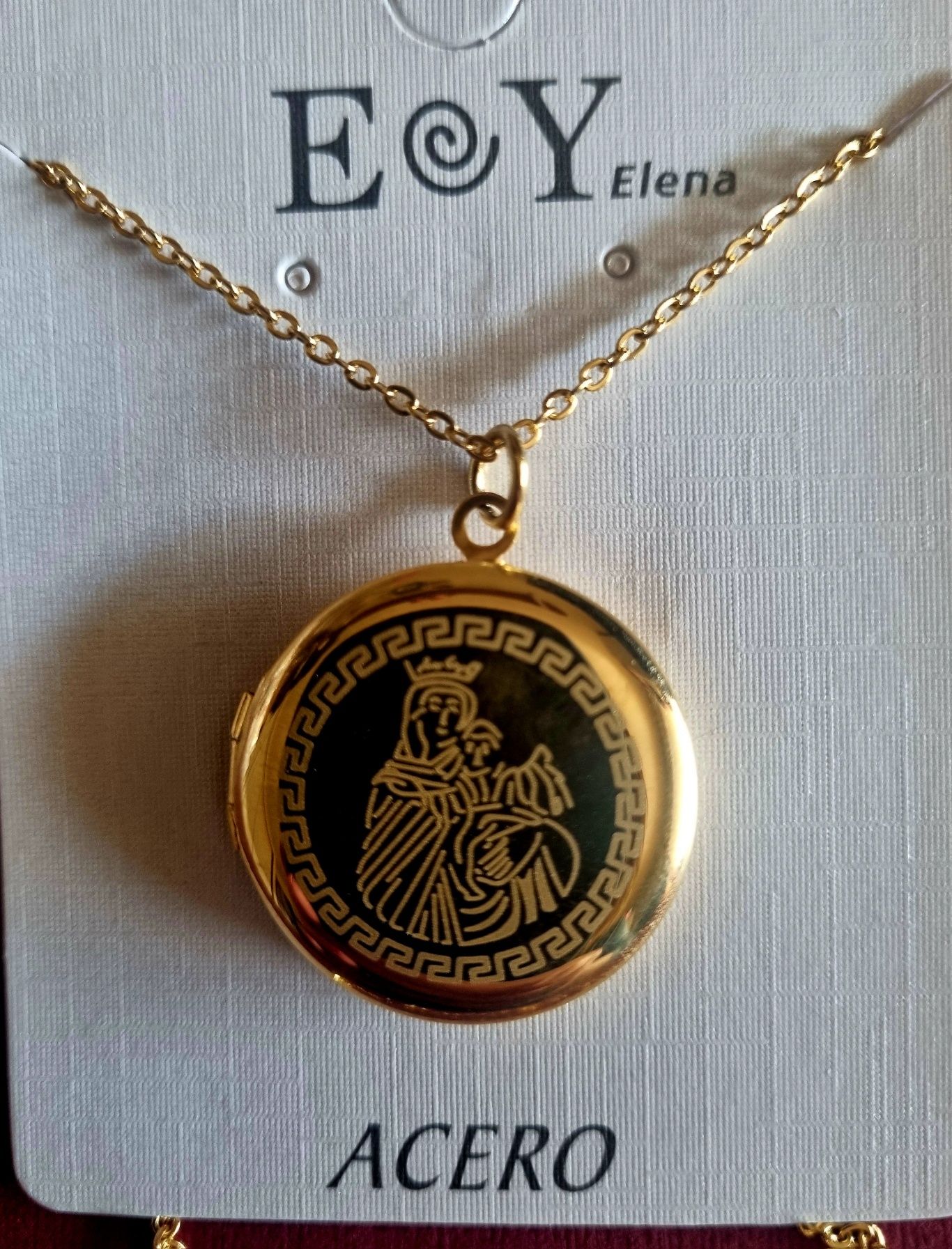 Colar/relicário dourado, em aço, com a Nossa Senhora. Tem extensor