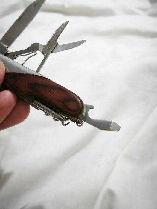 Canivete multifunções com acabamento em madeira e metal.