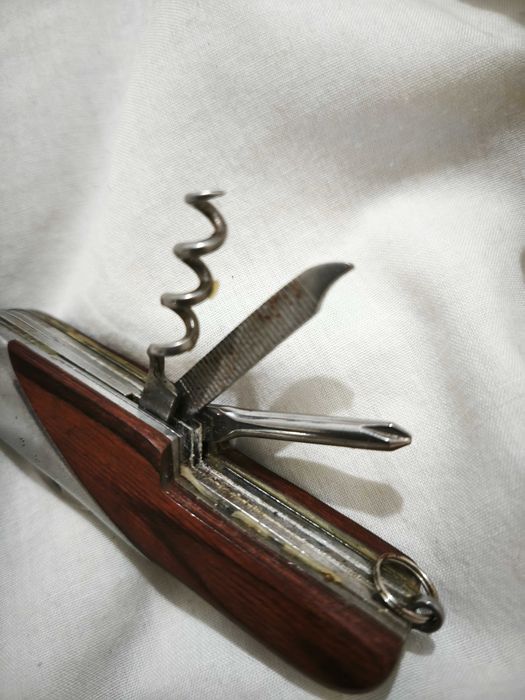 Canivete multifunções com acabamento em madeira e metal.