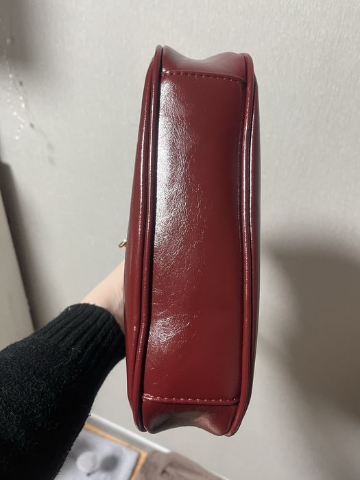 Сумка бордового кольору.