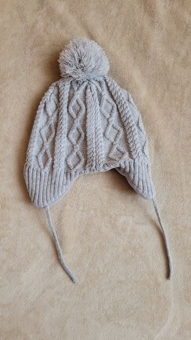 92 Zimowa czapka dziecięca szara z pomponem i wiązaniem pod szyją