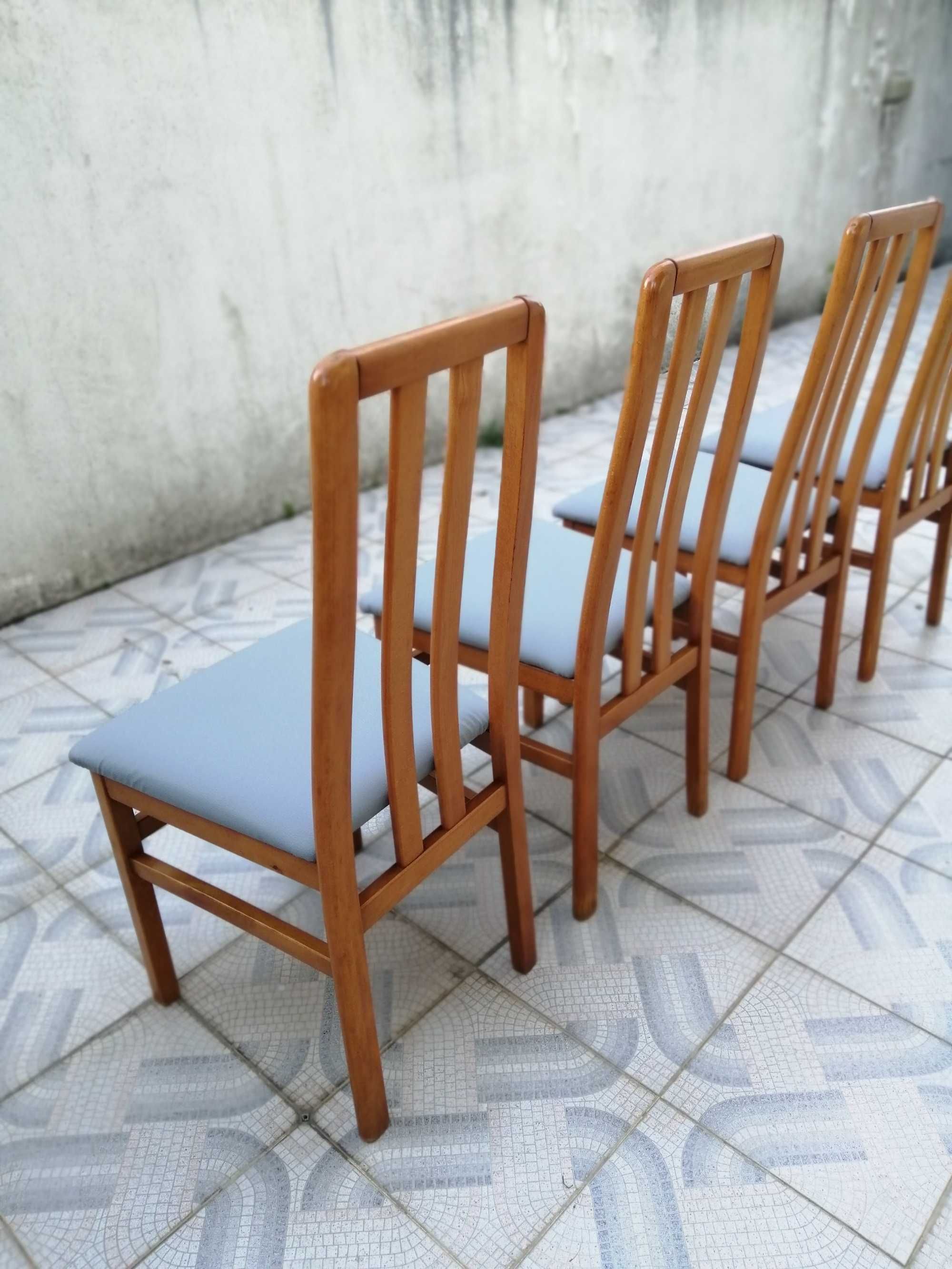 Cadeiras em madeira estofadas a napa cinzenta.