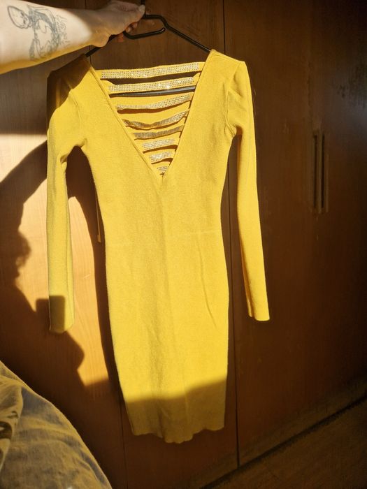 Obcisła sweterkowa sukienka z pięknie zdobionymi plecami, wycięcia