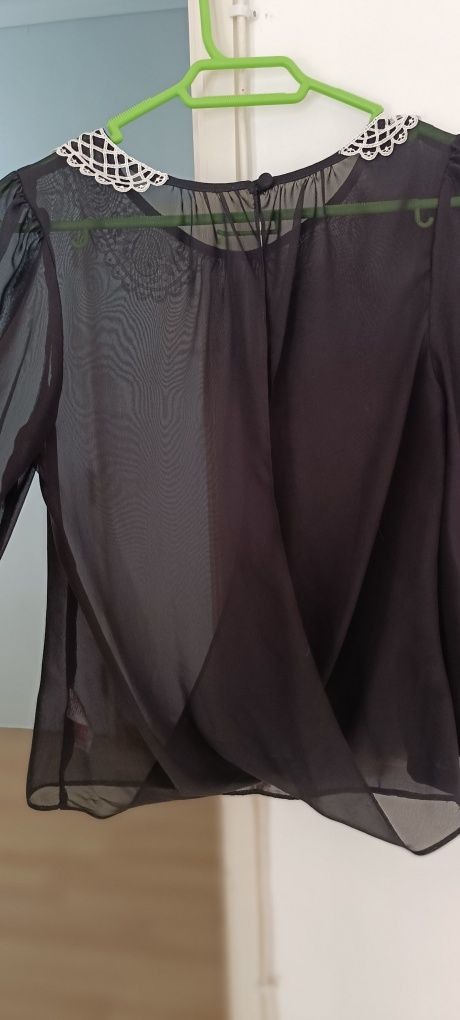 Camisa preta com gola bordada em branco. Aberta atrás. Tecido transpar