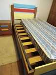 Cama individual com estrado e colchão.