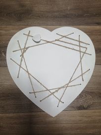 Drewniana biała ramka w kształcie serca z jutowym sznurkiem.