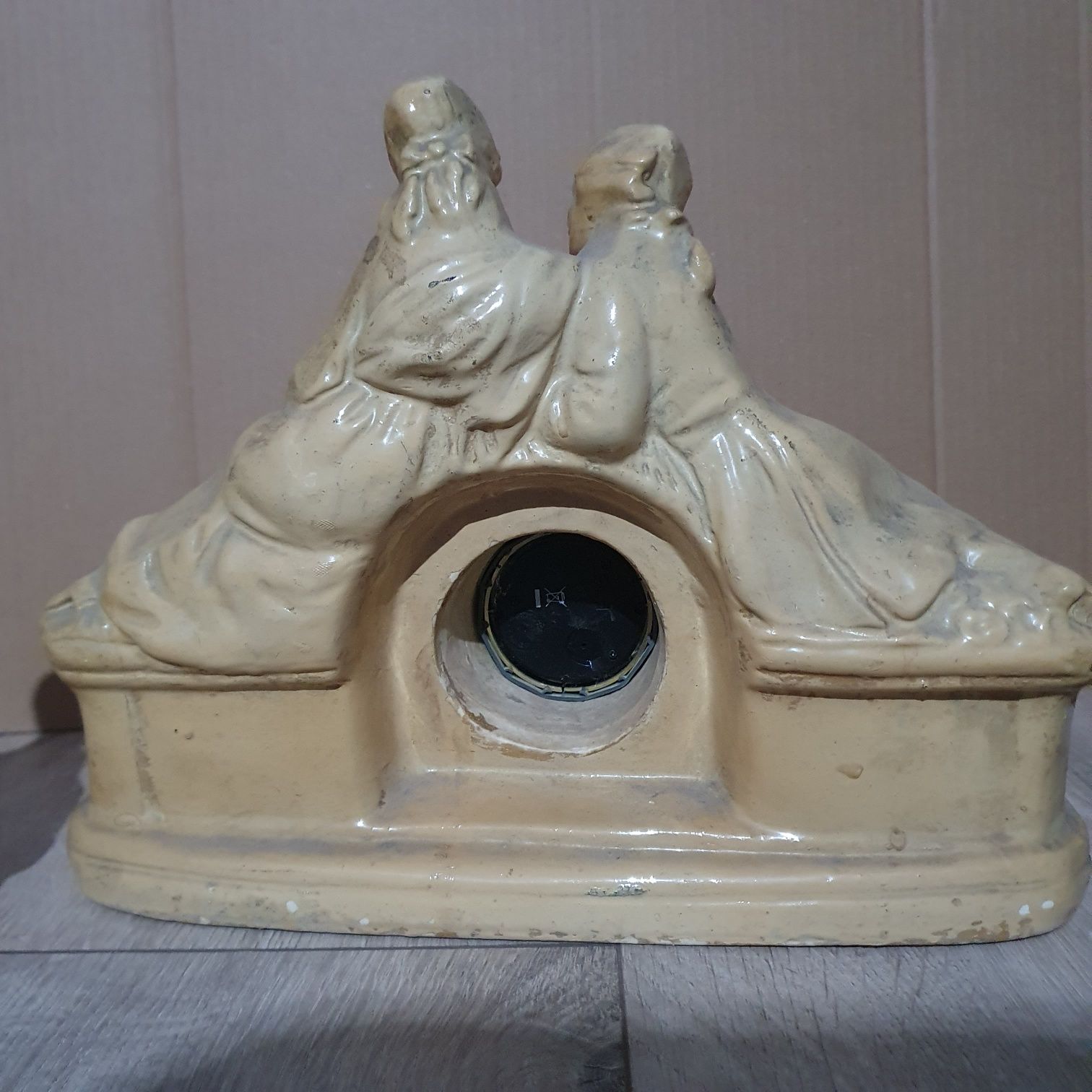Stary ceramiczny zegar z dwoma figurkami.