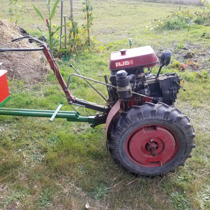 Mikrociągnik w zestawie z glebogryzarką, przyczepą i z papierami.