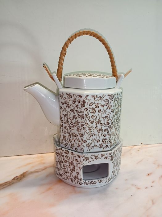 Bule de chá em cerâmica com aquecedor integrado, apresentando um padrã