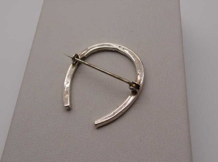 Antyczna srebrna broszka podkowa zielone szmaragdowe kamienie.