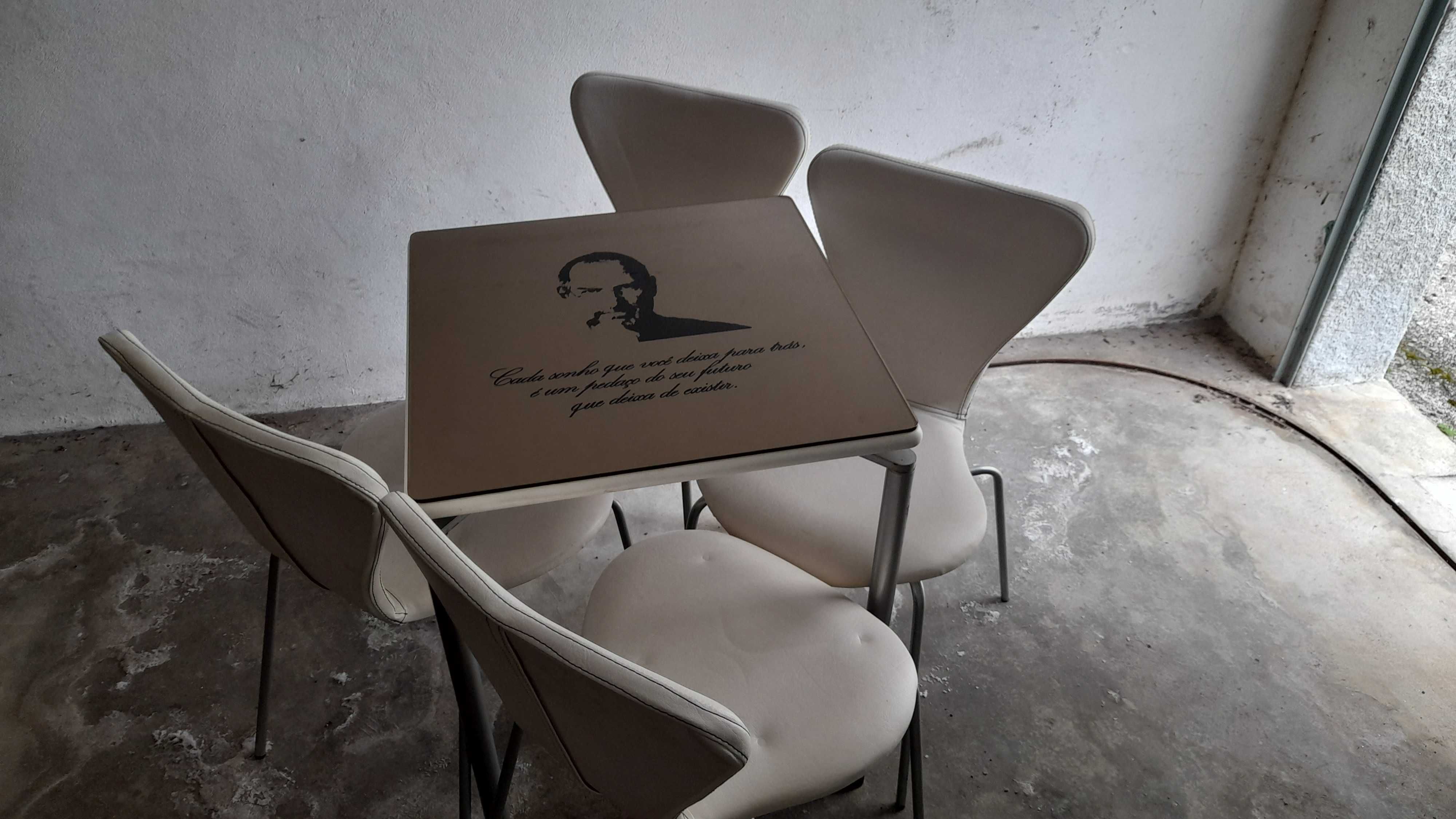 4 mesas com 16 cadeiras, personalizada com grandes figuras desenhadas.