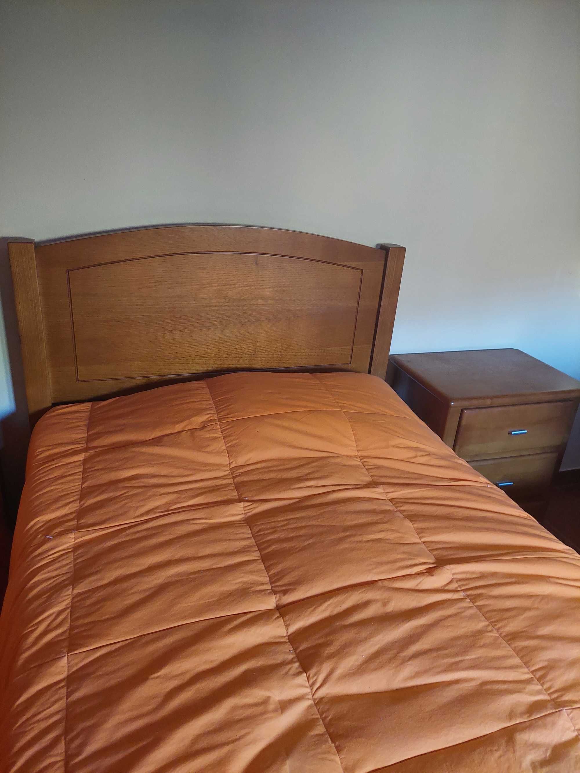 Duas camas individuais com mesa de cabeceira e estrado