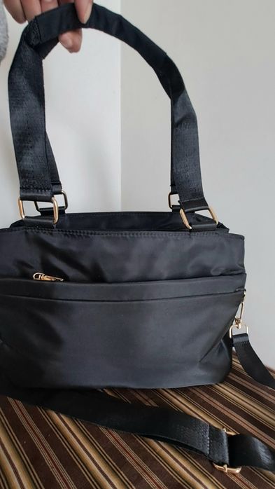 Carteira preta em tecido impermeável com várias divisórias, pratica e