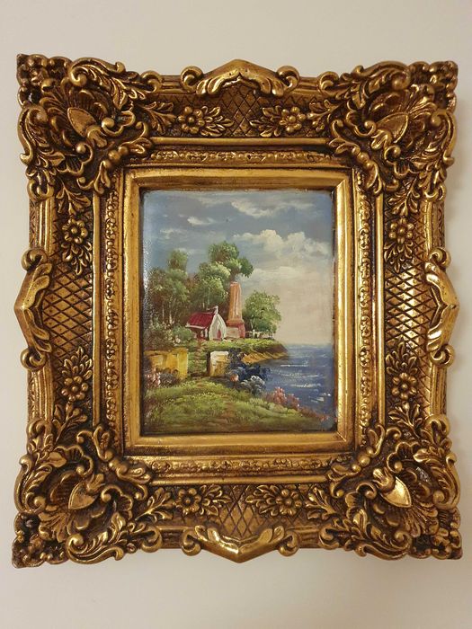 Obrazy i duże lustro z bogato zdobionymi ramami