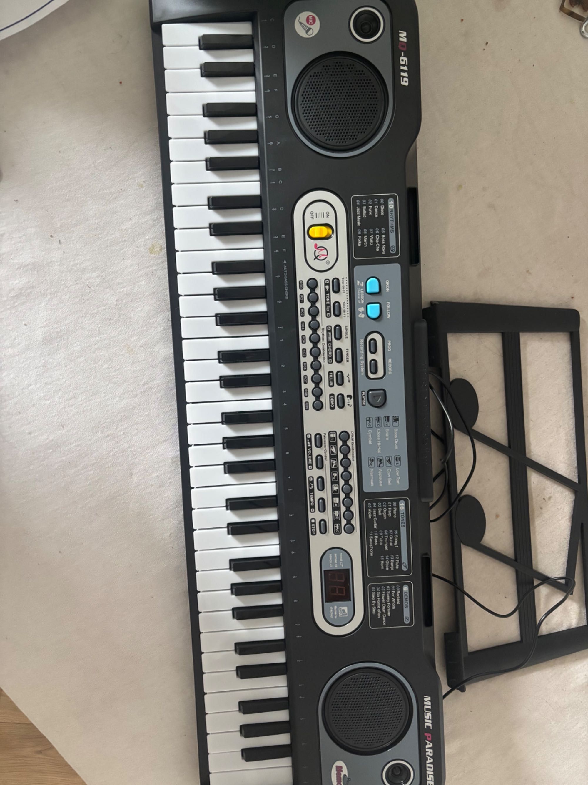 Keyboard z mikrofonem, ładowarką i instrukcją obsługi.