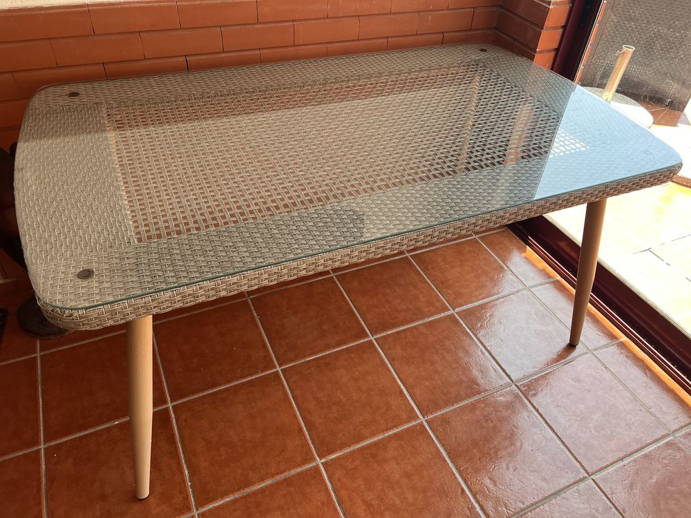 Mesa de exterior com tampo de vidro.