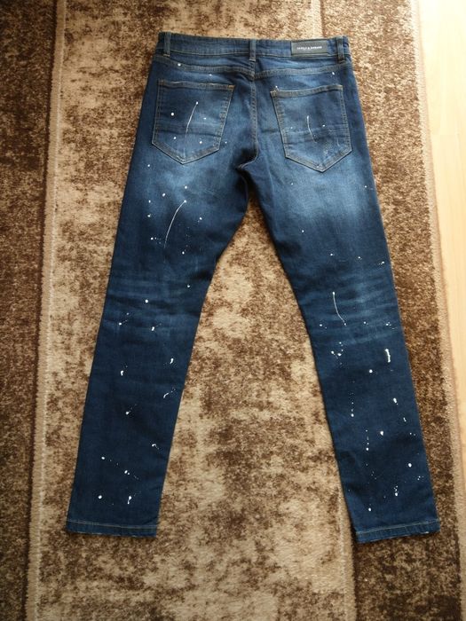 spodnie jeansowe z przetarciami dziurami i kropkami imitujacymi farbe