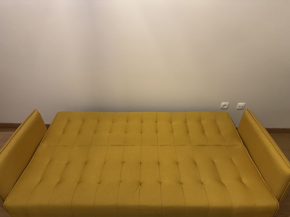 Sofá amarelo com abertura para sofá cama