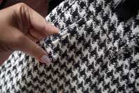Markowe spodnie Pierre Cardin z kieszeniami L. Wzór tkaniny w pepitkę.