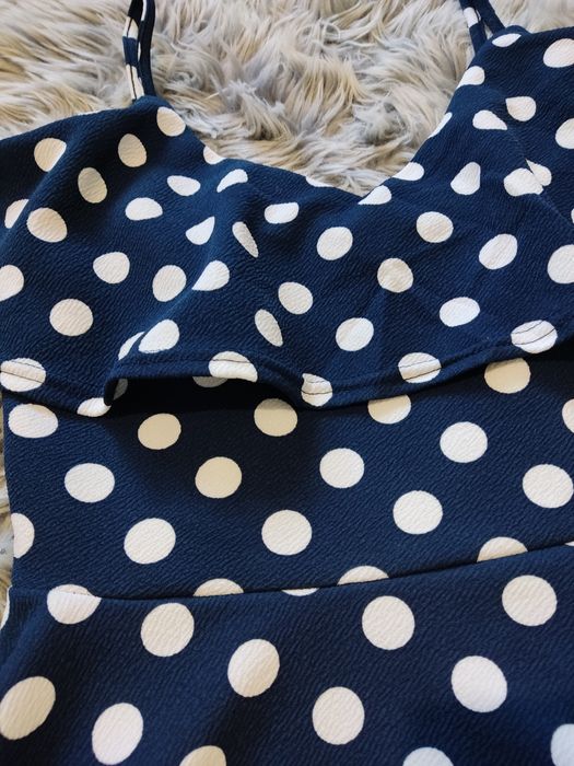 Granatowa sukienka w grochy na ramiączkach rozkloszowana z falbanką