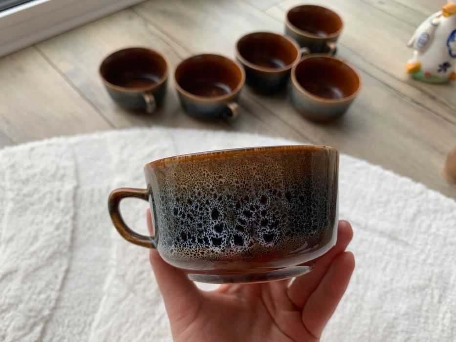 sześć filiżanek plus porcelanowa kaczka, plus sześć glinianych naczyń