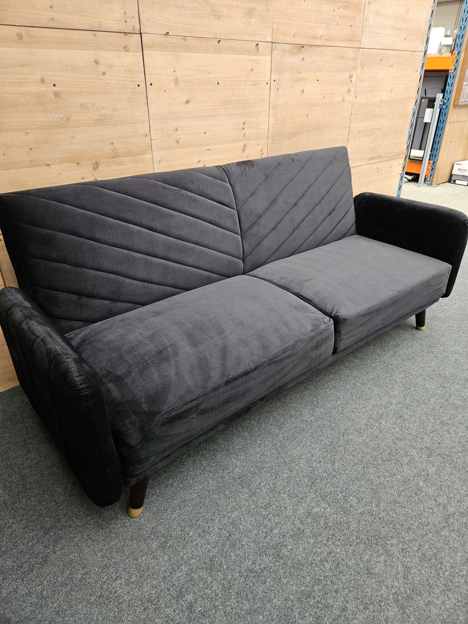 Czarna welurowa sofa z rozkładanym oparciem